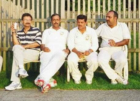 Four players in whites sitting on a bench