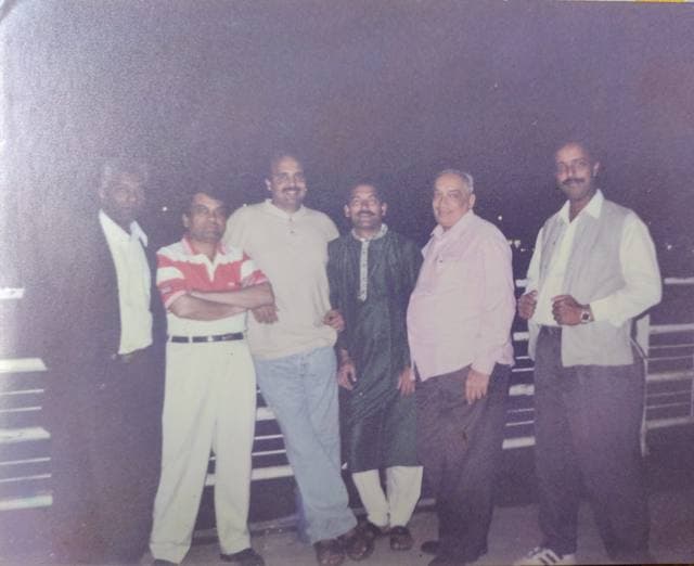 Six men standing together in an old photograph