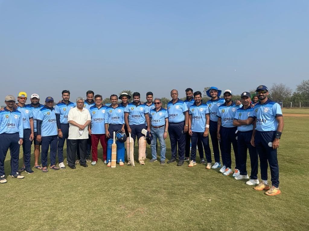 A squad in light-blue kit standing in a wide arc on a ground